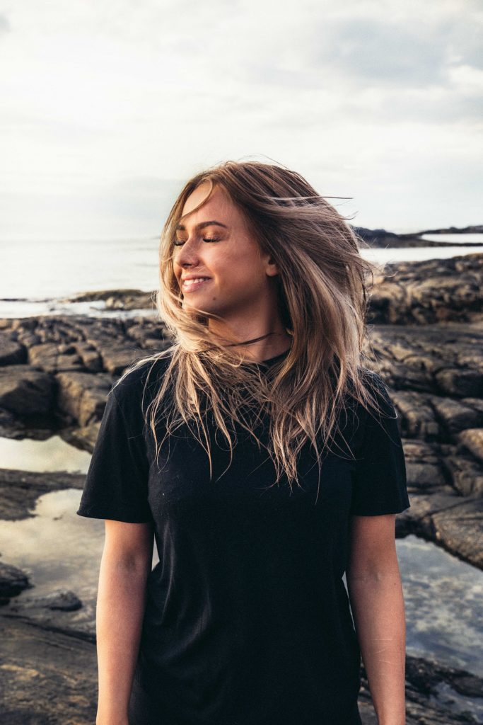 Woman stands and waves hair in the wind