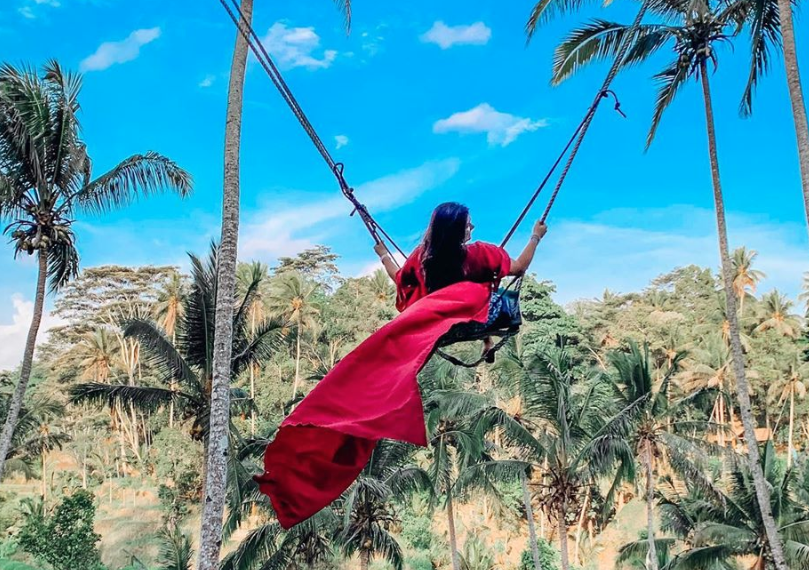 Girl Swinging Through Forest