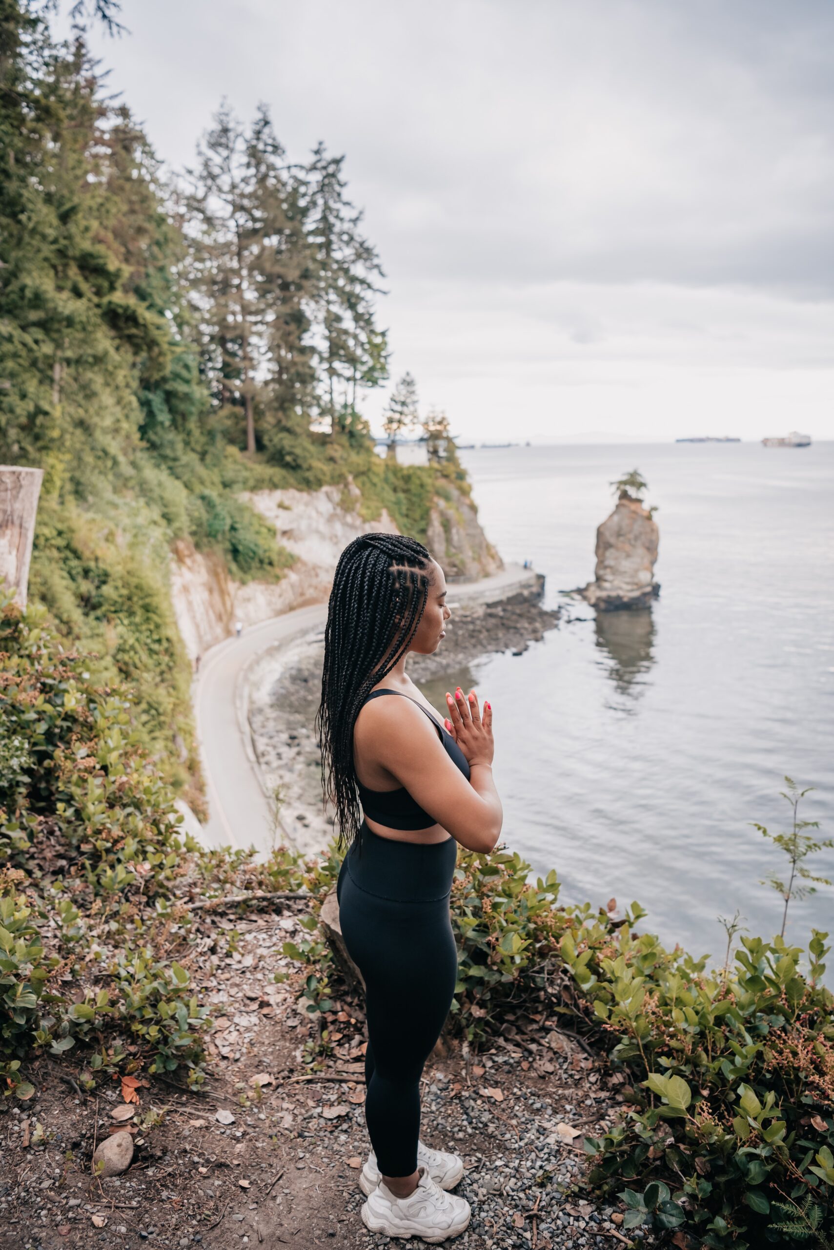Woman standing outside in a meditative state, absorbing the nature around her.