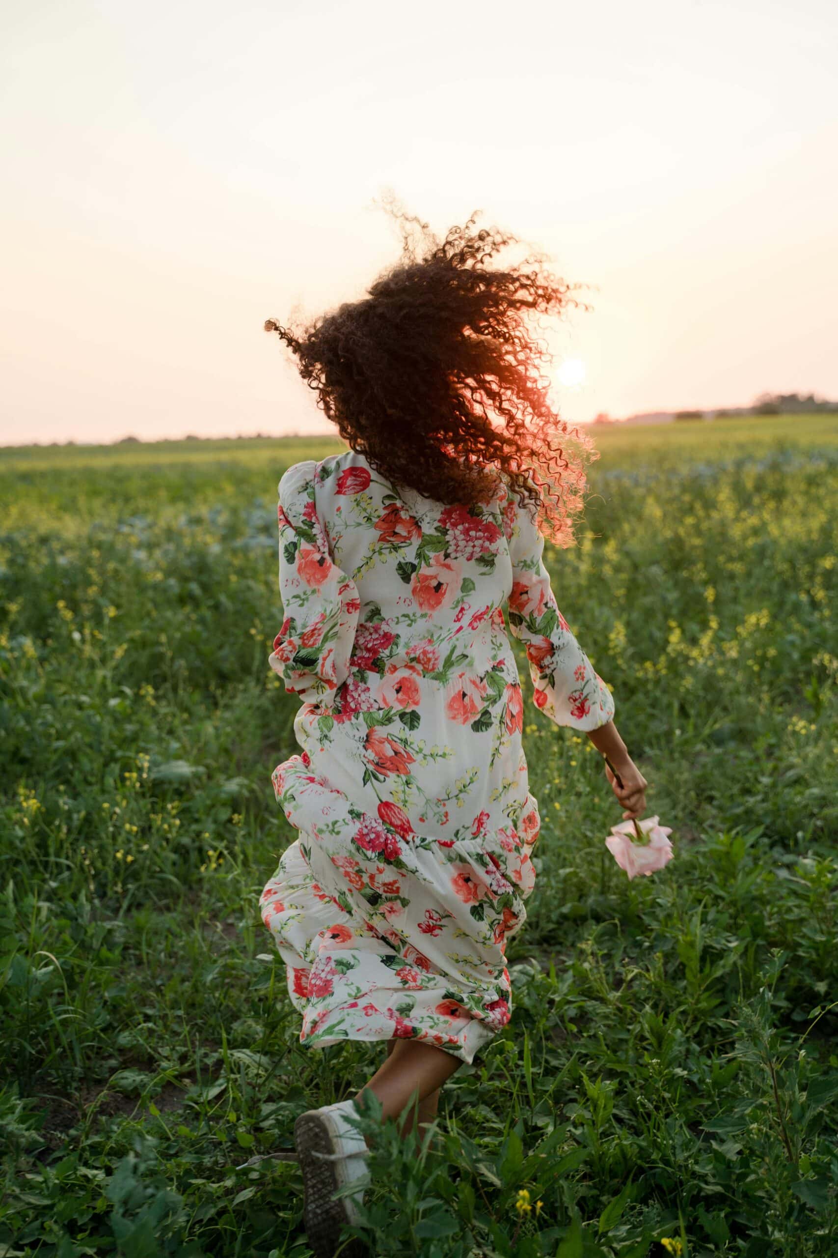 7 tips to feeling your best. This is an image of a woman who is happily running through a nature field.