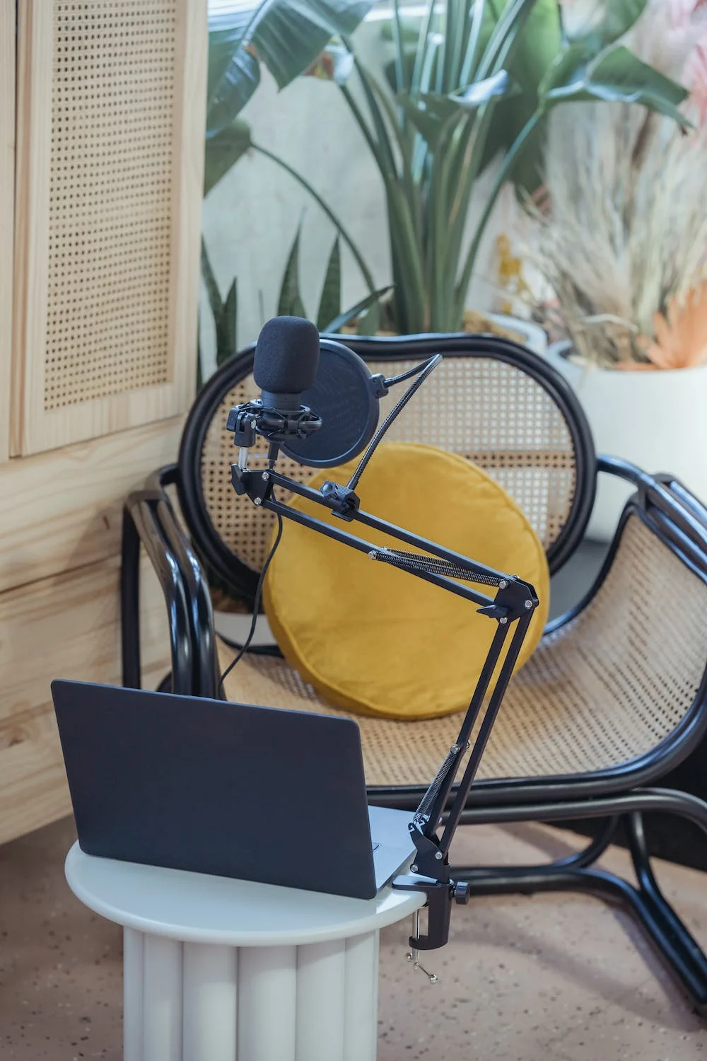 This is for a post about how to start your own podcast. The image is of a podcast set up with a chair, computer, and microphone.